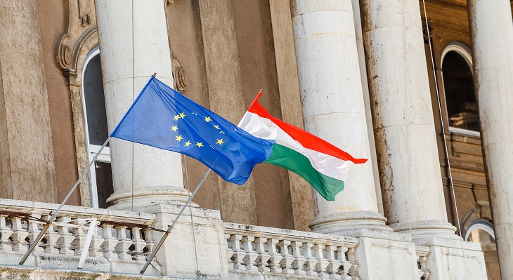 Die europäische und ungarische Flagge hängen an einem Gebäude.