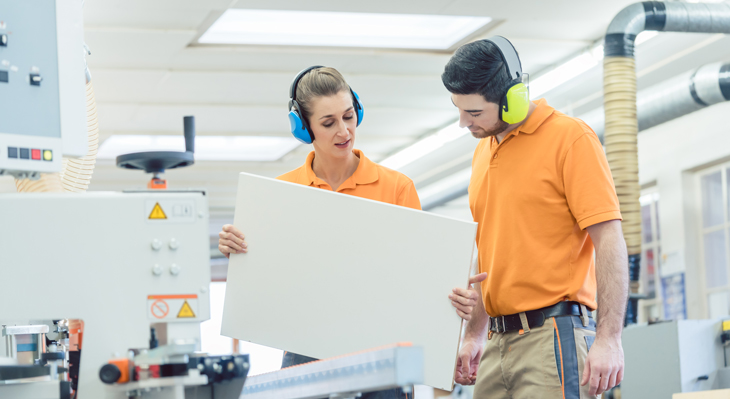 Tischler prüfen bei Qualitätskontrolle ein Werkstück 