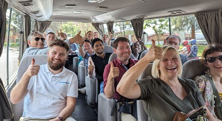 Personen in einem Bus in Ruanda halten lächelnd ihre Daumen hoch